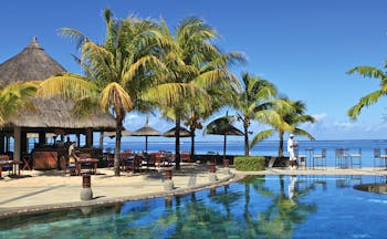 Heritage Awali Mauritius pool terrace overlooking sea palm trees