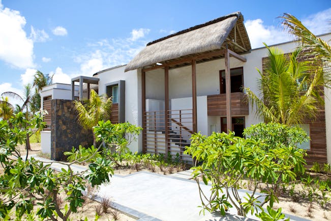 Long Beach exterior, white building with thatched roof, stone walkway, green shrubbery