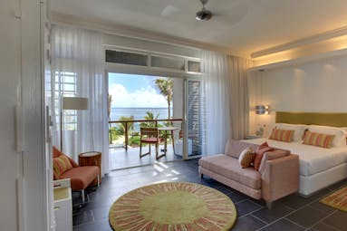 Long Beach sea view suite, double bed, light pink sofa, balcony with sea view, bright modern decor