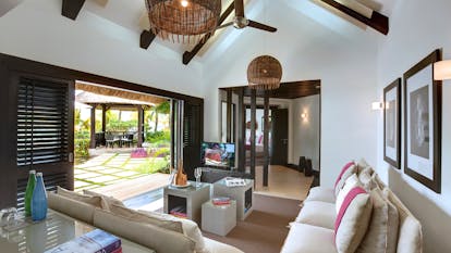 Beach front villa lounge area with sofa and doors opening onto terrace and beach  