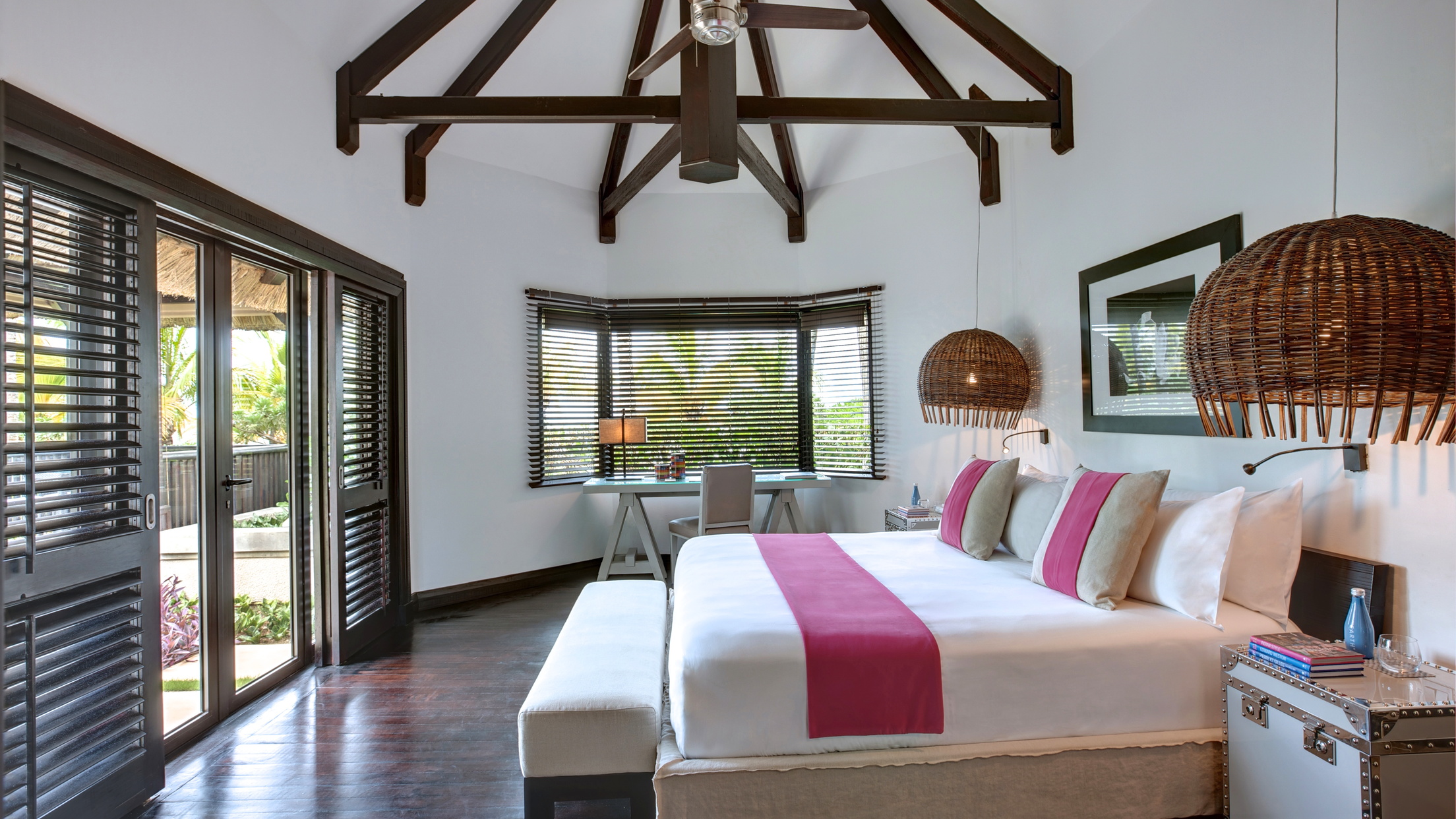 Beach front villa bedroom with large double bed and doors opening up onto beach