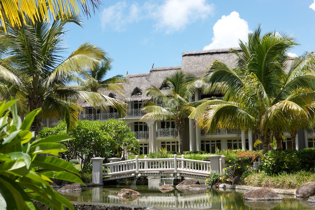 Exterior with palm trees, river with a bridge and hotel building 