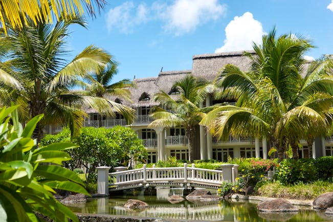 Exterior with palm trees, river with a bridge and hotel building 