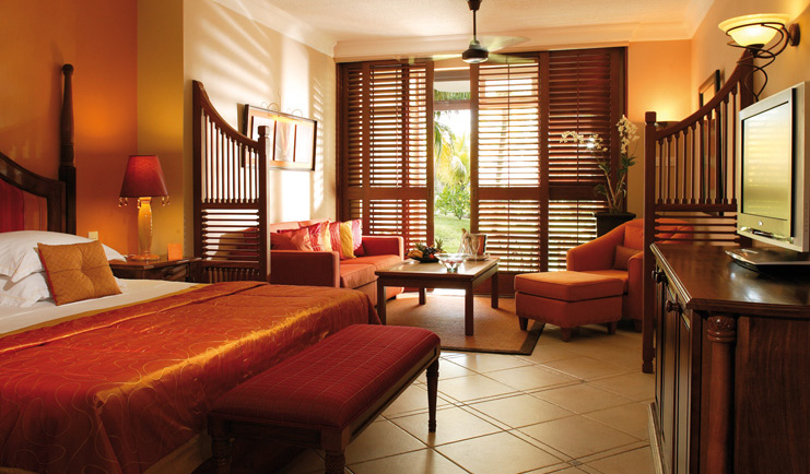 Junior suite with orange and beige colour scheme, large double bed and terrace balcony