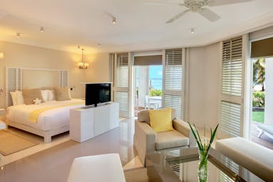 Ocean suite with television, double bed, terrace balcony and arm chairs 