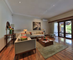 Exclusive suite pool villa living area with large sofas, coffee table and doors opening onto an outdoor terrace area