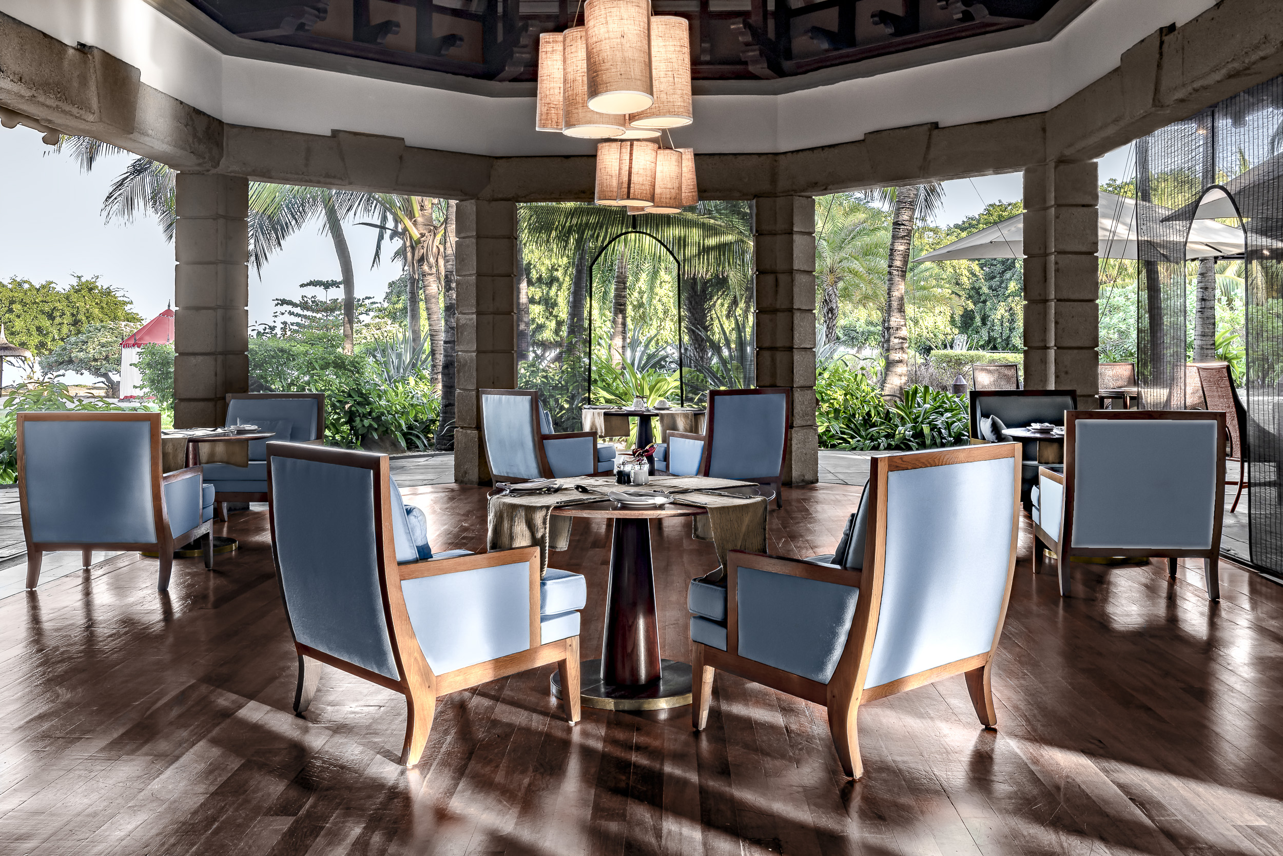 Restaurant dining area with tables and chairs set out in large wooden floored room 