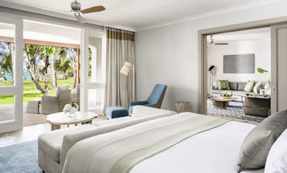 Beach front suite room with large double bed, terrace balcony opening onto the beach and living space