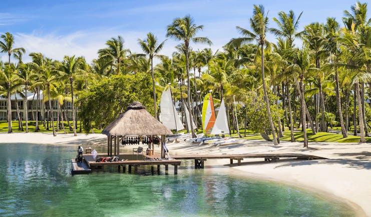 Boat house on the edge of sea with sails in background for water sports