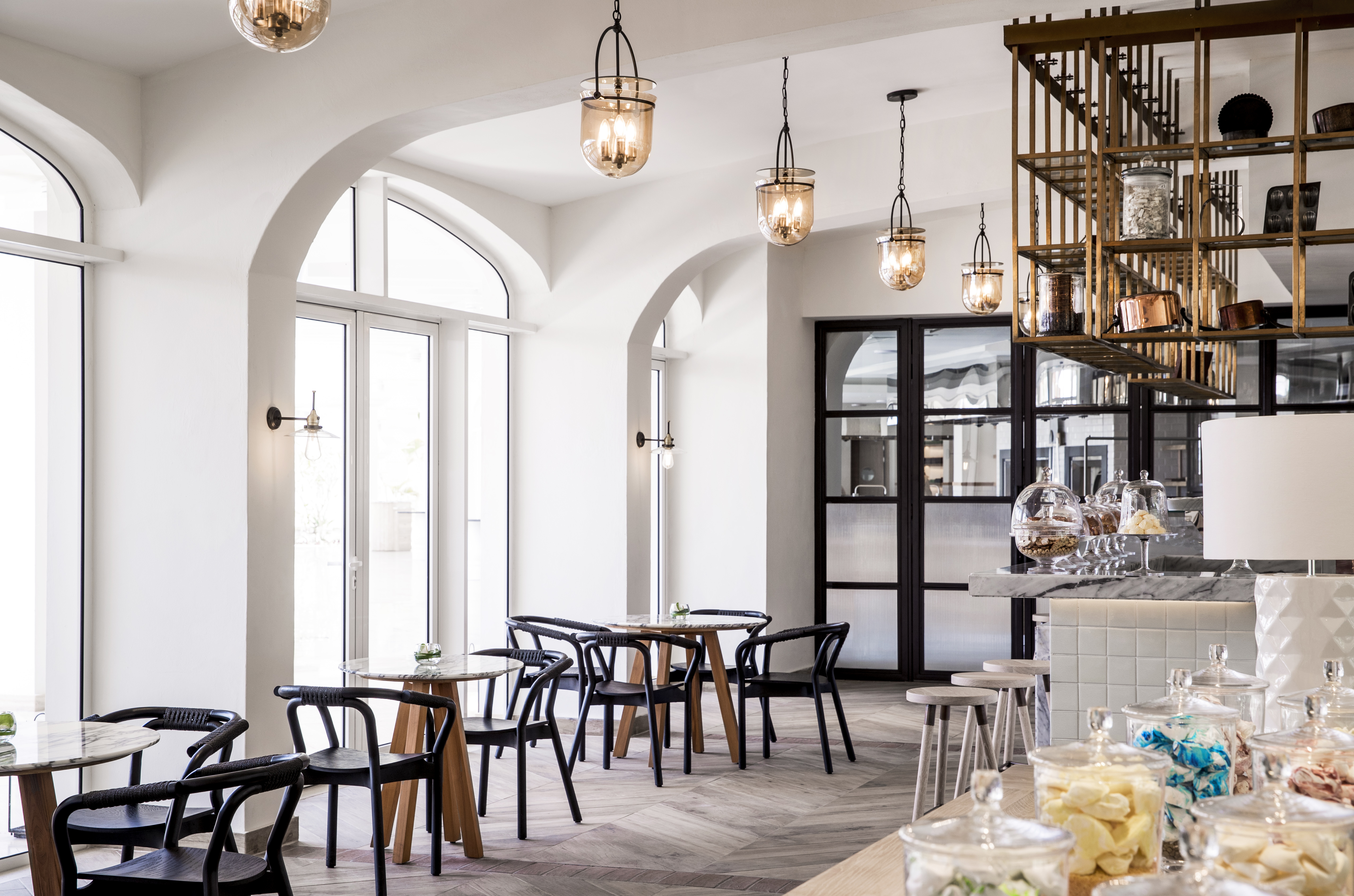 Indoor cafe called L'Artisan with tables and chairs set up in light cafe 