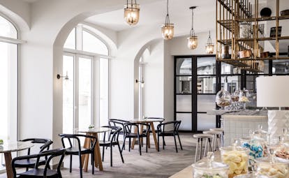 Indoor cafe called L'Artisan with tables and chairs set up in light cafe