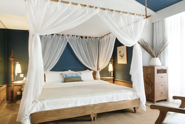 Paradise Cove deluxe premium room, canopied bed, blue walls, wooden floo, modern decor
