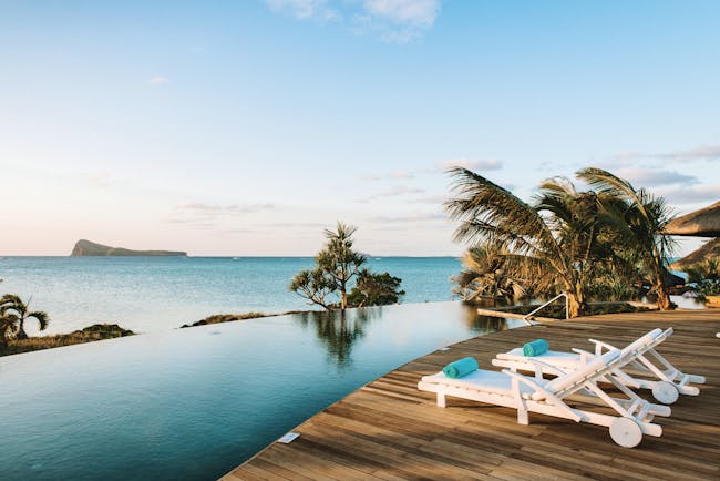 Paradise Cove infinity pool, decking, sun loungers, palm trees, overlooking sea