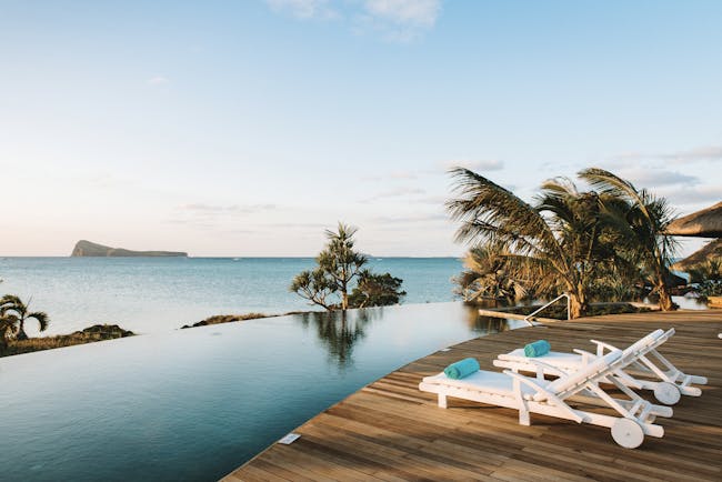 Paradise Cove infinity pool, decking, sun loungers, palm trees, overlooking sea
