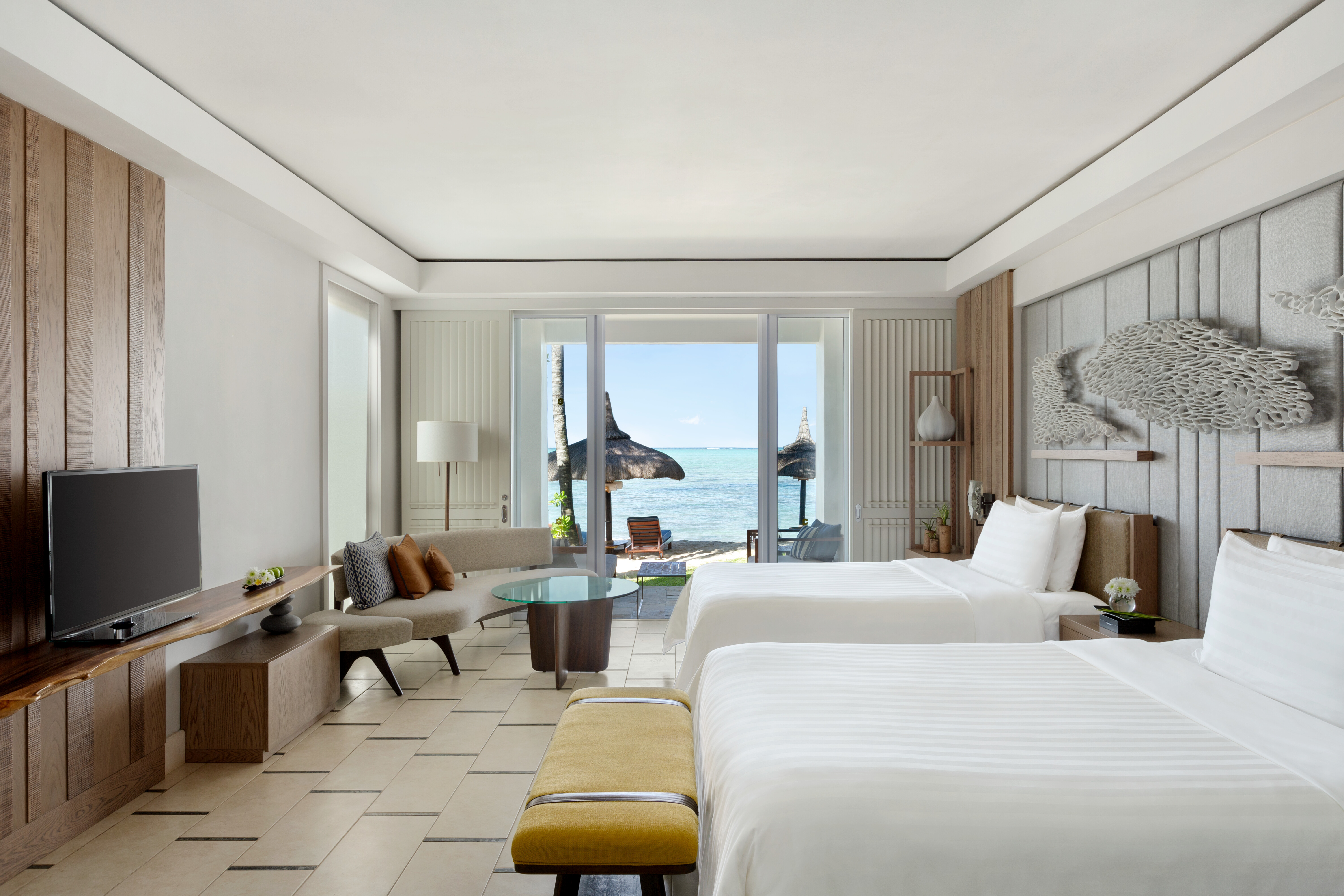 Twin room with beach access balcony, television and seating area