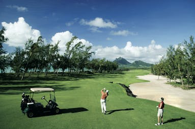 Shangri La Le Touessrok Mauritius golf men playing golf mountain and ocean view