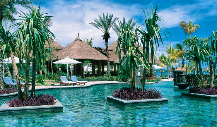 Shangri La Le Touessrok Mauritius swimming pool palm trees thatched pavilions loungers umbrellas