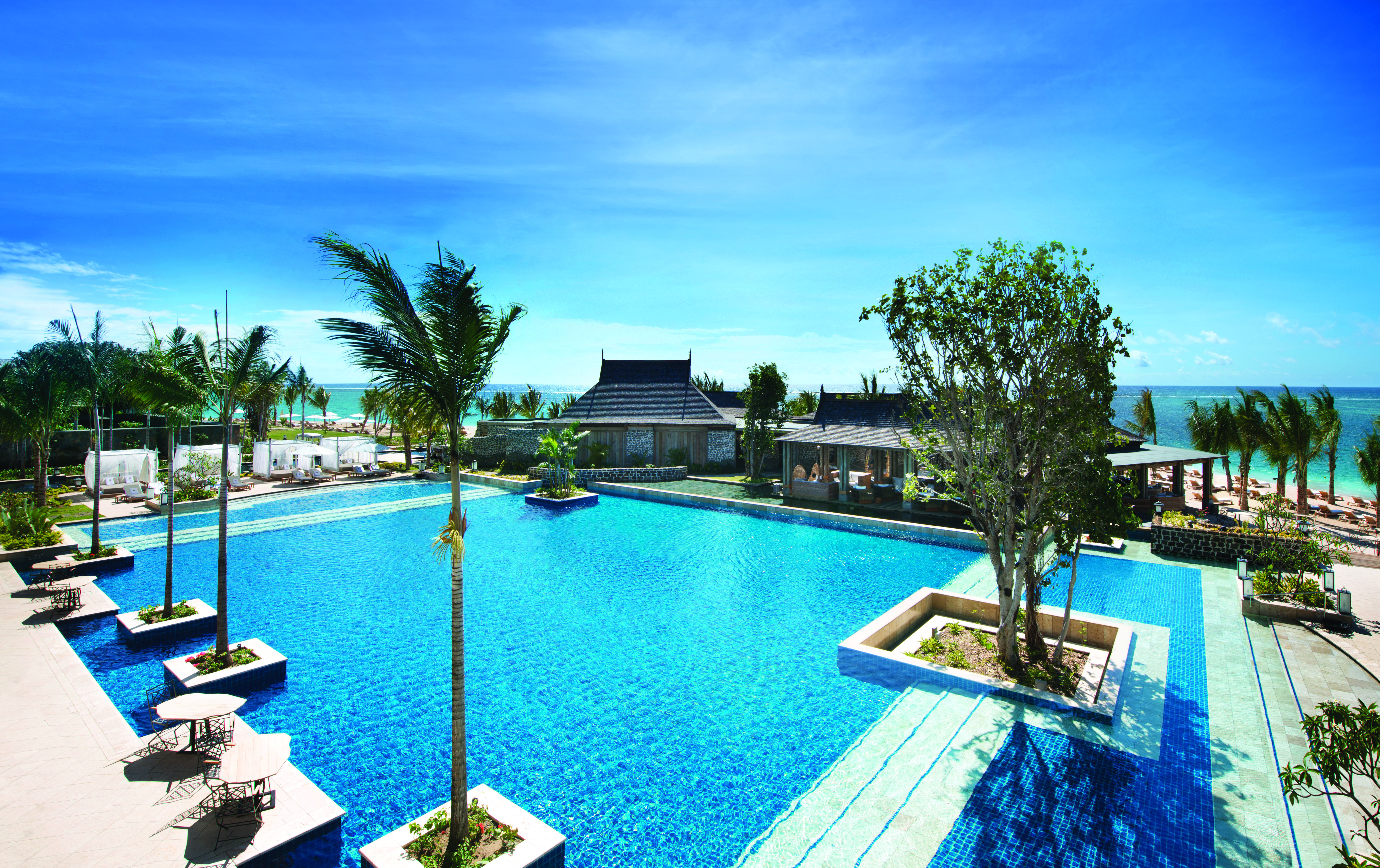 Swimming pool with palm trees built into the floors and views out over the sea
