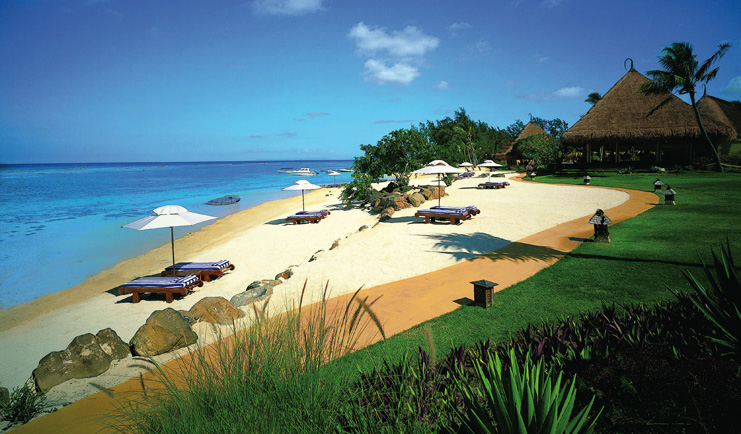 Beach with sun loungers and beach hut umbrellas near the sea