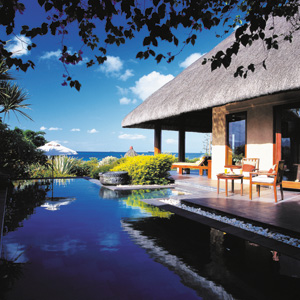 Royal Villa pool with umbrella and chairs around