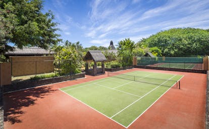 Tennis court with greenery around and blue skies