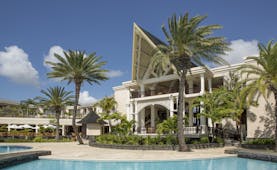 Exterior of hotel with palm trees around 