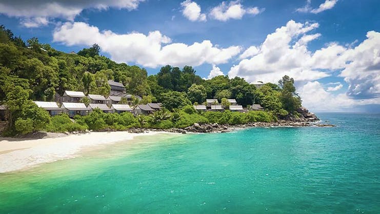 Carana Beach Hotel beach, clear turquoise sea, white sand, villas nestled in tropical greenery