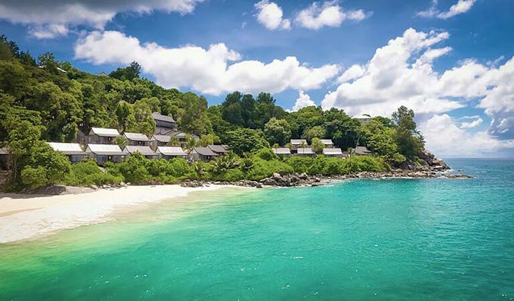 Carana Beach Hotel beach, clear turquoise sea, white sand, villas nestled in tropical greenery