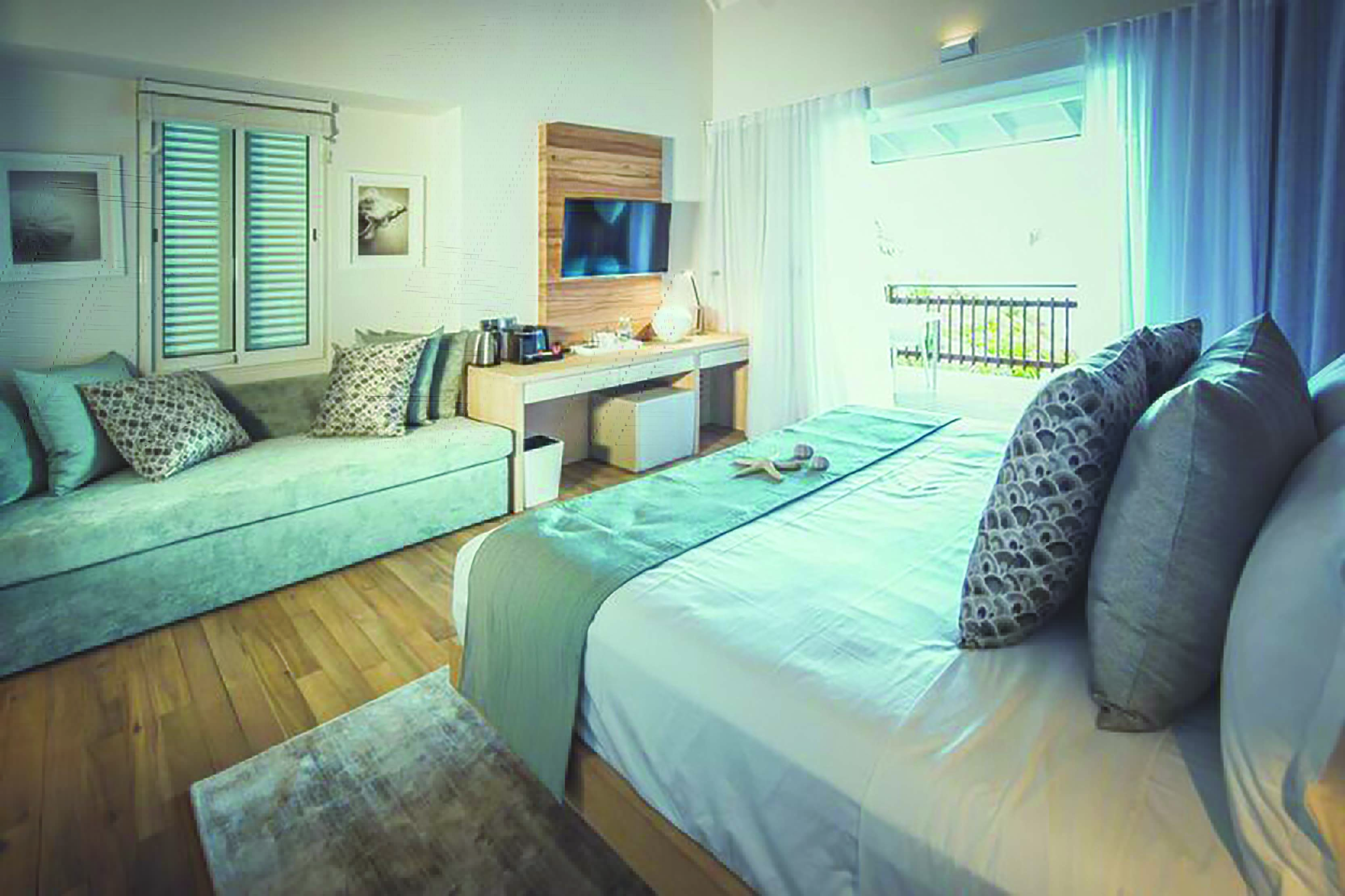Carana Beach Hotel chalet bedroom bed, sofa, fresh modern decor, access to terrace