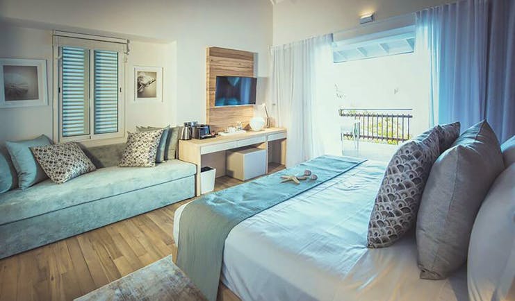 Carana Beach Hotel chalet bedroom bed, sofa, fresh modern decor, access to terrace