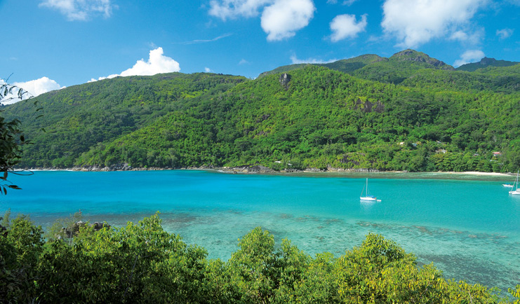 Constance Ephelia Resort Seychelles aerial view green waters tree covered mountain 