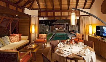 Constance Ephelia Resort Seychelles family villa dining table sofa view of outdoor pool