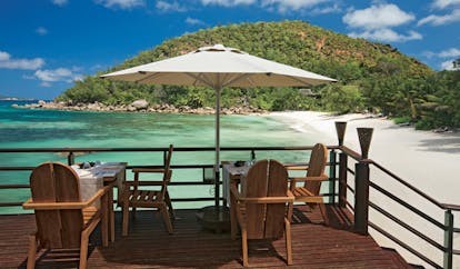Constance Lemuria Seychelles beachfront restaurant decked dining area umbrella