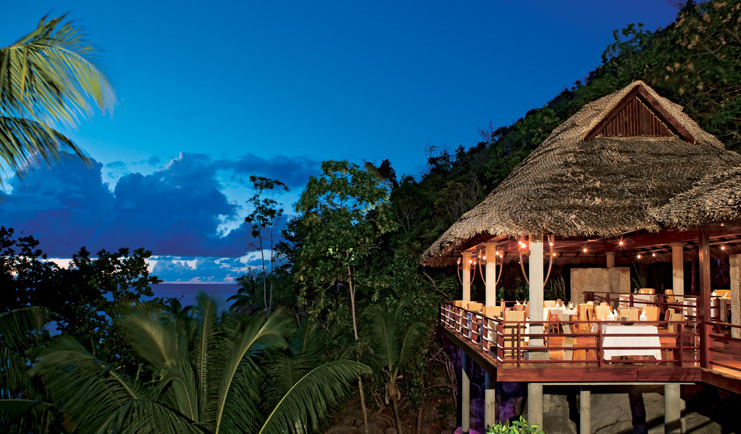 Constance Lemuria Seychelles Legend restaurant outdoor thatched pavilion palm trees night