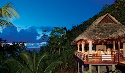Constance Lemuria Seychelles Legend restaurant outdoor thatched pavilion palm trees night