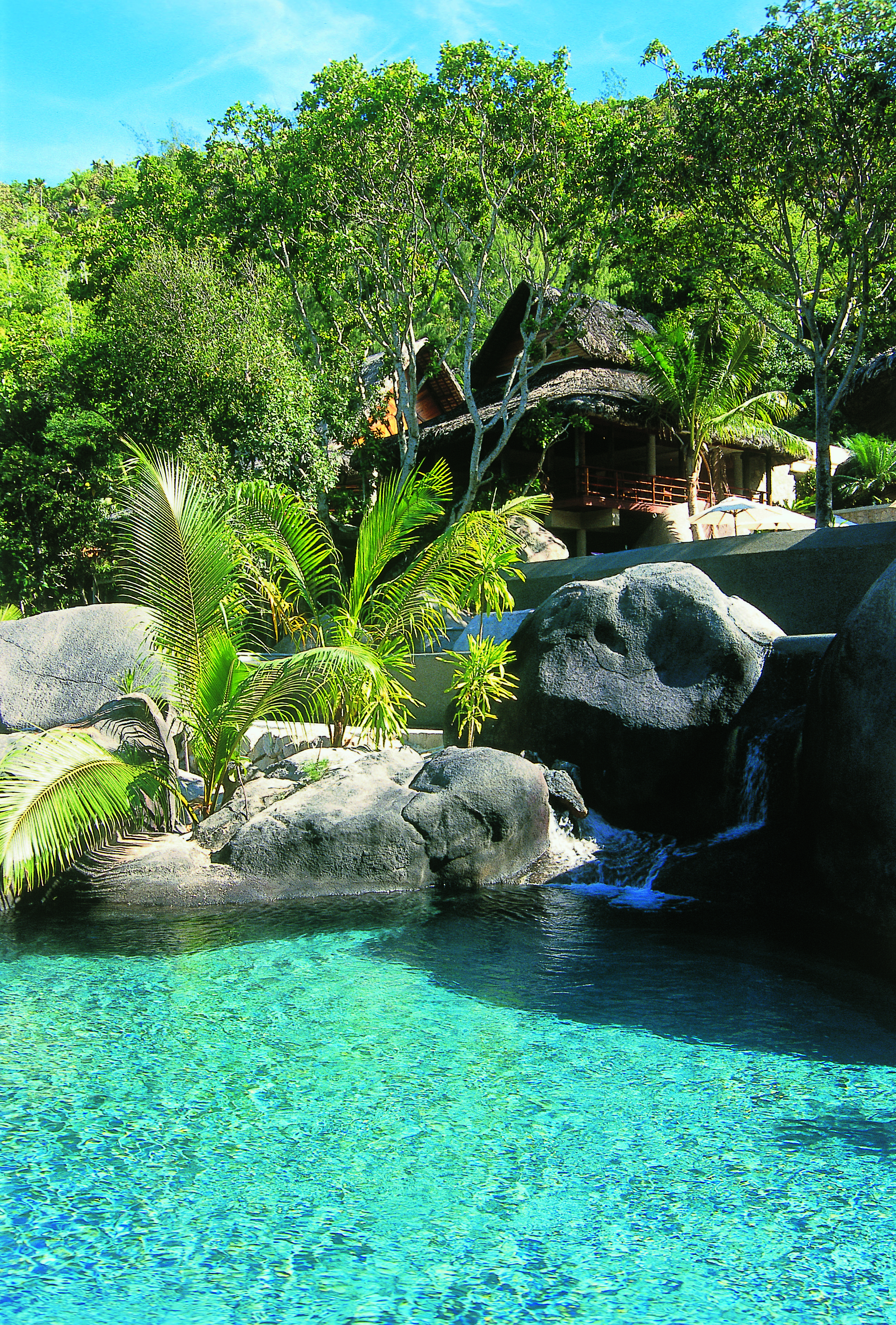 Constance Lemuria Seychelles outdoor pool rocks greenery