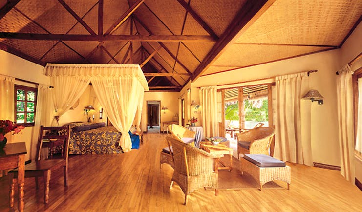 Denis Island Seychelles deluxe cottage exposed beams four poster bed lounge seating area 