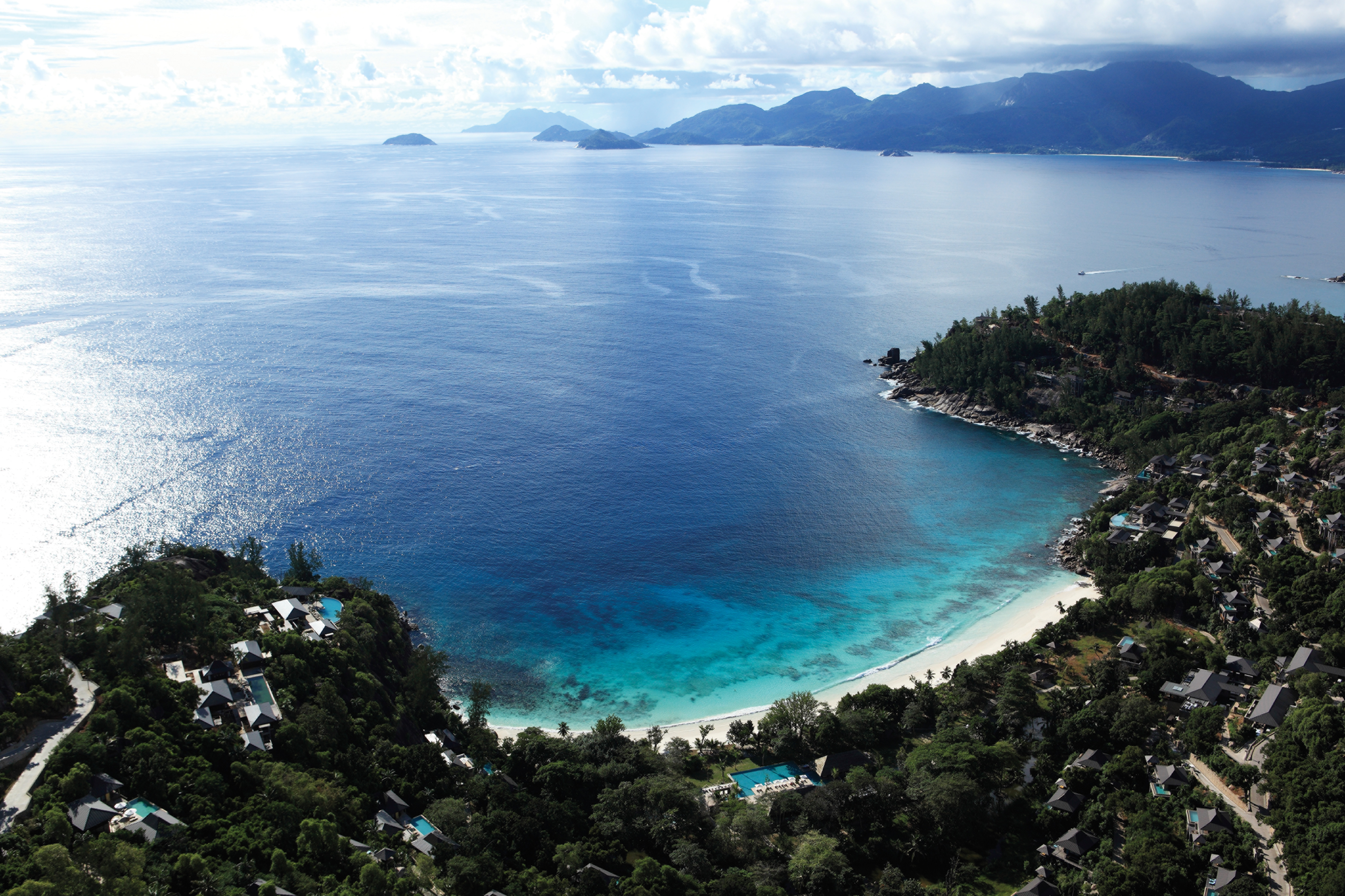 Aerial view of the beach and resort looking over the sea, beach and mountains in the distance