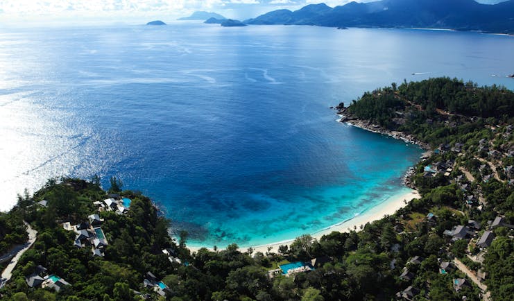Aerial view of the beach and resort looking over the sea, beach and mountains in the distance