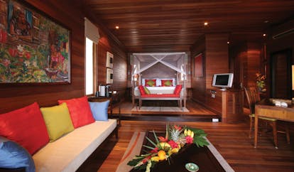 Hilton Northolme Seychelles villa interior wooden walls and floors floor poster bed sitting area tropical scene painting