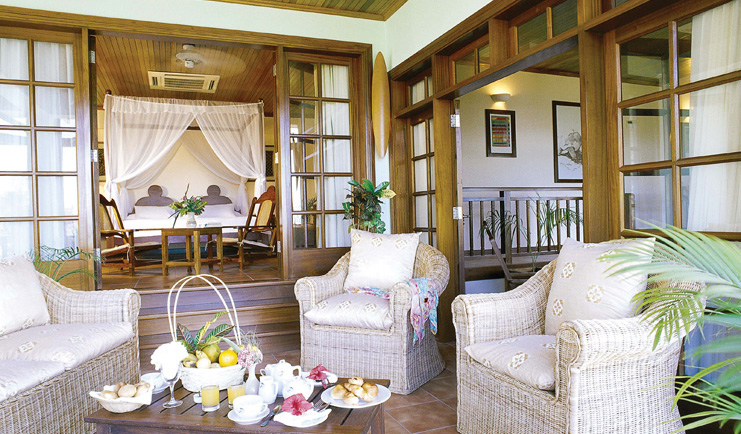 Hotel L'Archipel Seychelles bedroom four poster bed outdoor terrace wicker seating area