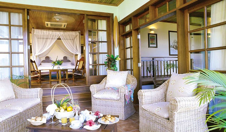 Hotel L'Archipel Seychelles bedroom four poster bed outdoor terrace wicker seating area