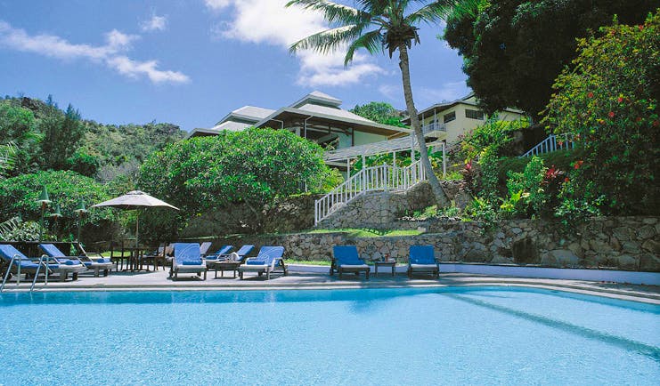 Hotel L'Archipel Seychelles outdoor pool sun loungers umbrellas
