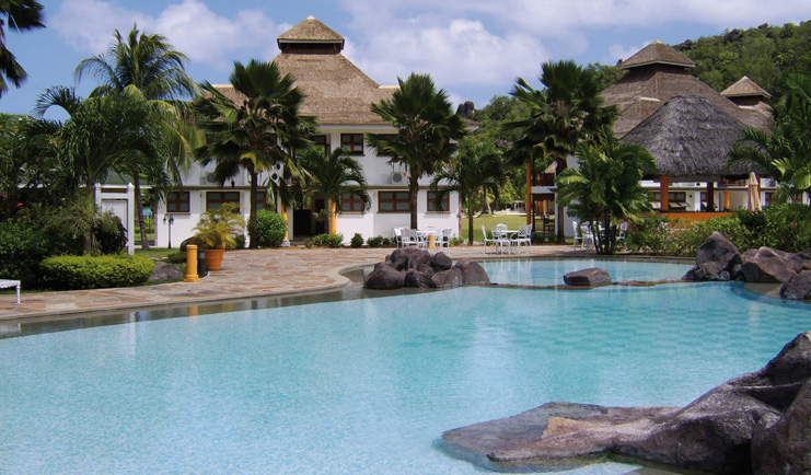Domaine de la Reserve Seychelles exterior pool white building palm trees