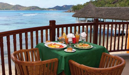 Domaine de la Reserve Seychelles outdoor dining terrace ocean and jetty view
