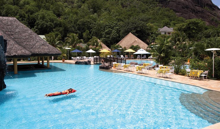 Domaine de la Reserve Seychelles outdoor pool bridge thatched pavilion loungers dining area