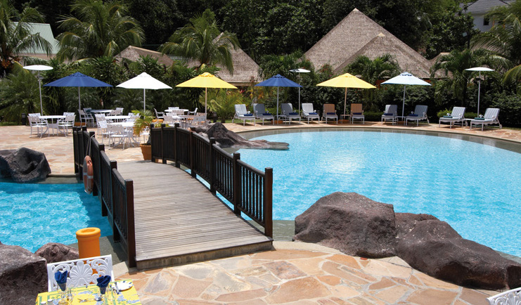 Domaine de la Reserve Seychelles pool bridge outdoor dining area loungers umbrellas