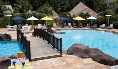 Domaine de la Reserve Seychelles pool bridge outdoor dining area loungers umbrellas