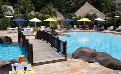 Domaine de la Reserve Seychelles pool bridge outdoor dining area loungers umbrellas