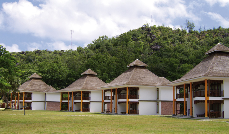 Domaine de la Reserve Seychelles villas white buildings with pointed thatched rooves gardens forest